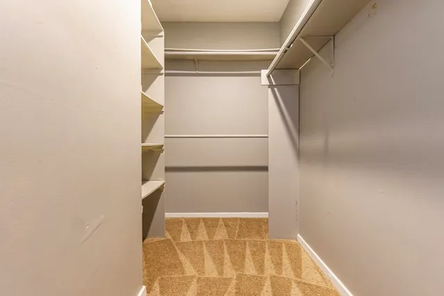 a view of walk in closet with empty racks