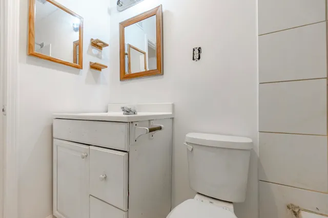 a bathroom with a toilet sink and mirror