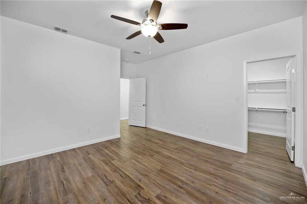 2906 Alcala Court Mission, TX 78572 - Photo 13 of 17 a view of an empty room with wooden floor closet and a ceiling fan
