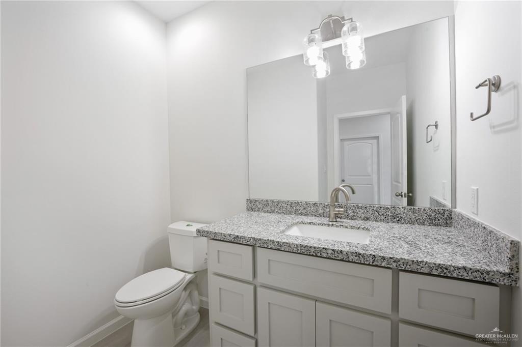 2906 Alcala Court Mission, TX 78572 - Photo 4 of 17 a bathroom with a granite countertop sink vanity mirror and toilet