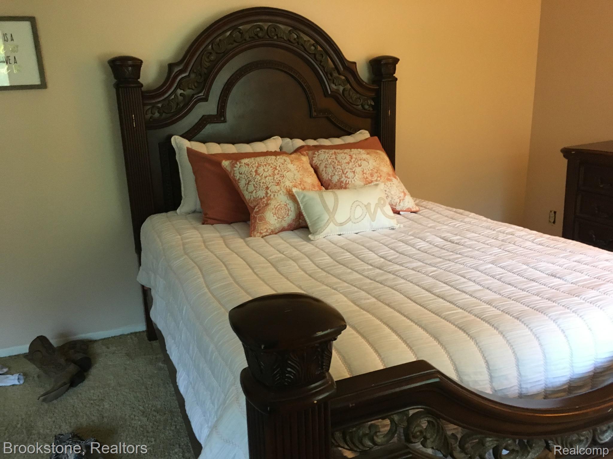 48632 Sugarbush Road, Unit 6 New Baltimore, MI 48047 - Photo 18 of 28 Elegant bedroom showcasing an ornately carved wooden bed frame with arched headboard and decorative finial posts