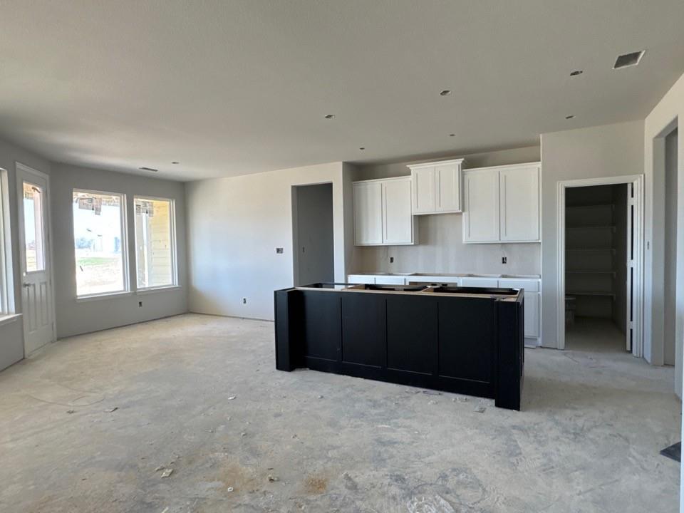 111 Brandywine Trail Rhome, TX 76078 - Photo 4 of 13 a kitchen with granite countertop a refrigerator and cabinets