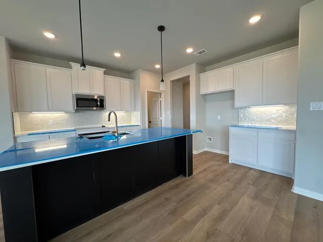 a kitchen with kitchen island a sink stainless steel appliances and cabinets
