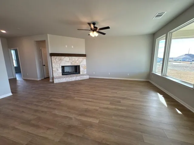 wooden floor fireplace and windows in an empty room