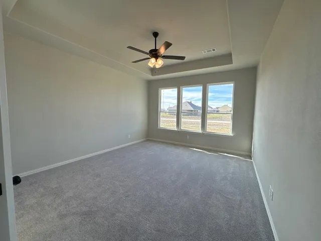 an empty room with a window and a ceiling fan