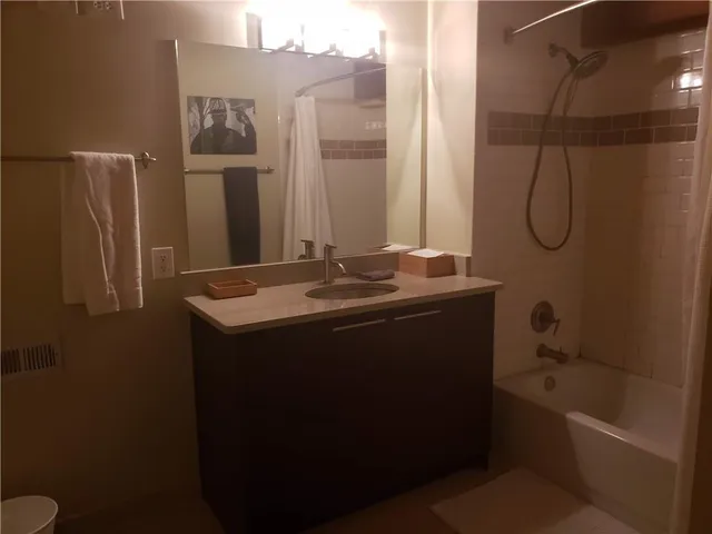 a bathroom with a granite countertop sink a toilet and shower