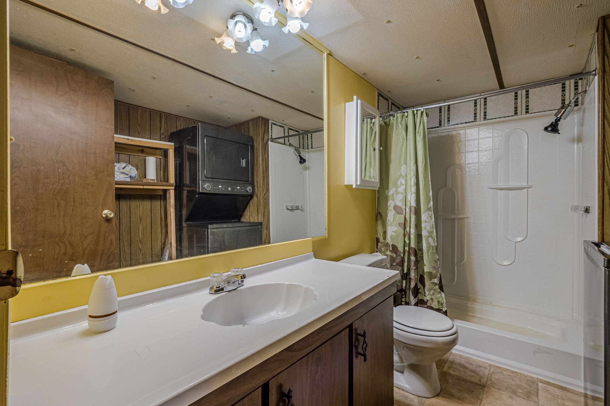 3251 E Road, Unit 22 Clifton, CO 81520 - Photo 18 of 29 a bathroom with a granite countertop sink a toilet a mirror a vanity and shower