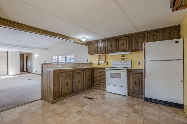 a kitchen with a white stove refrigerator and cabinets