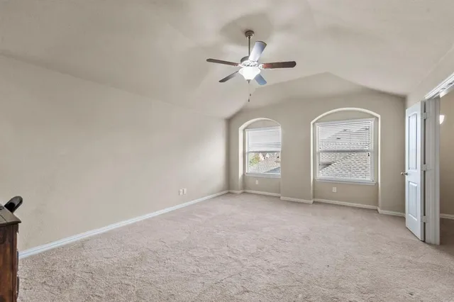 an empty room with fan and windows