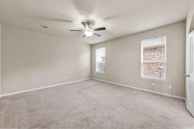 an empty room with a window and a ceiling fan