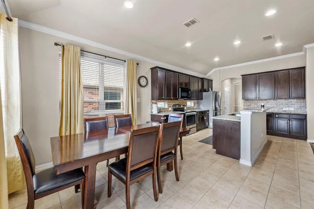 a view of a dining room with furniture a kitchen and chandelier