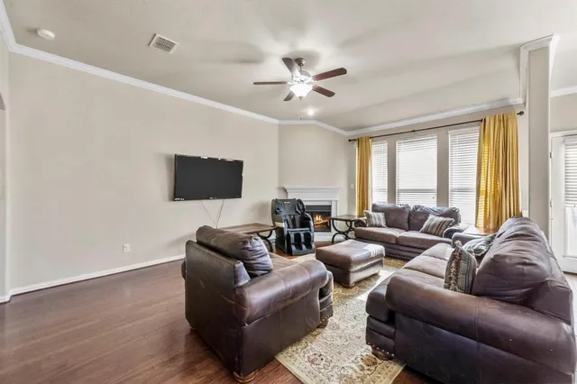 a living room with furniture a ceiling fan and a large window