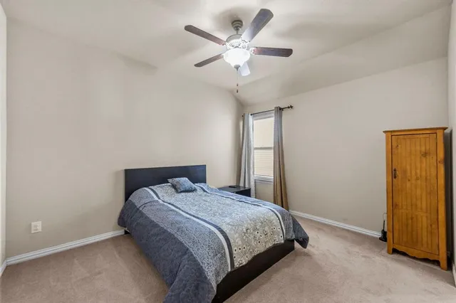 a bedroom with a bed and a ceiling fan