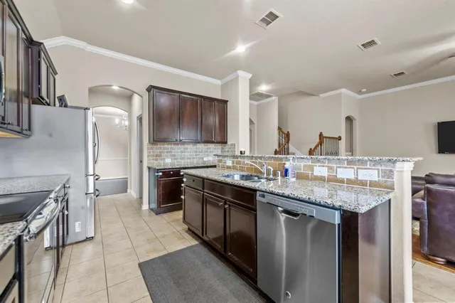 a kitchen with stainless steel appliances granite countertop a sink stove and cabinets