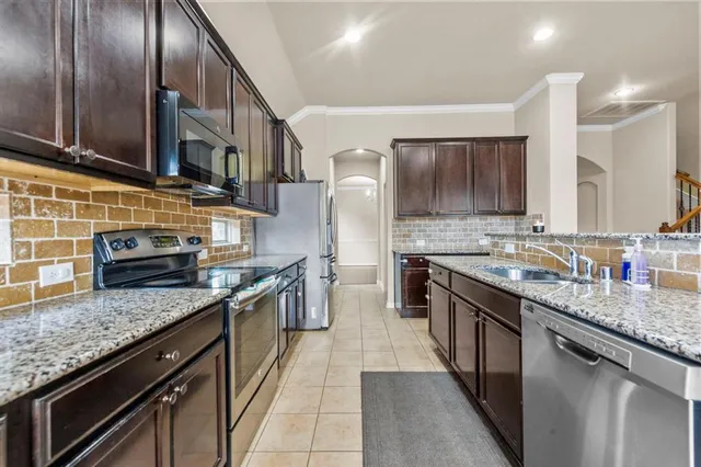 a kitchen with stainless steel appliances granite countertop a sink stove and cabinets