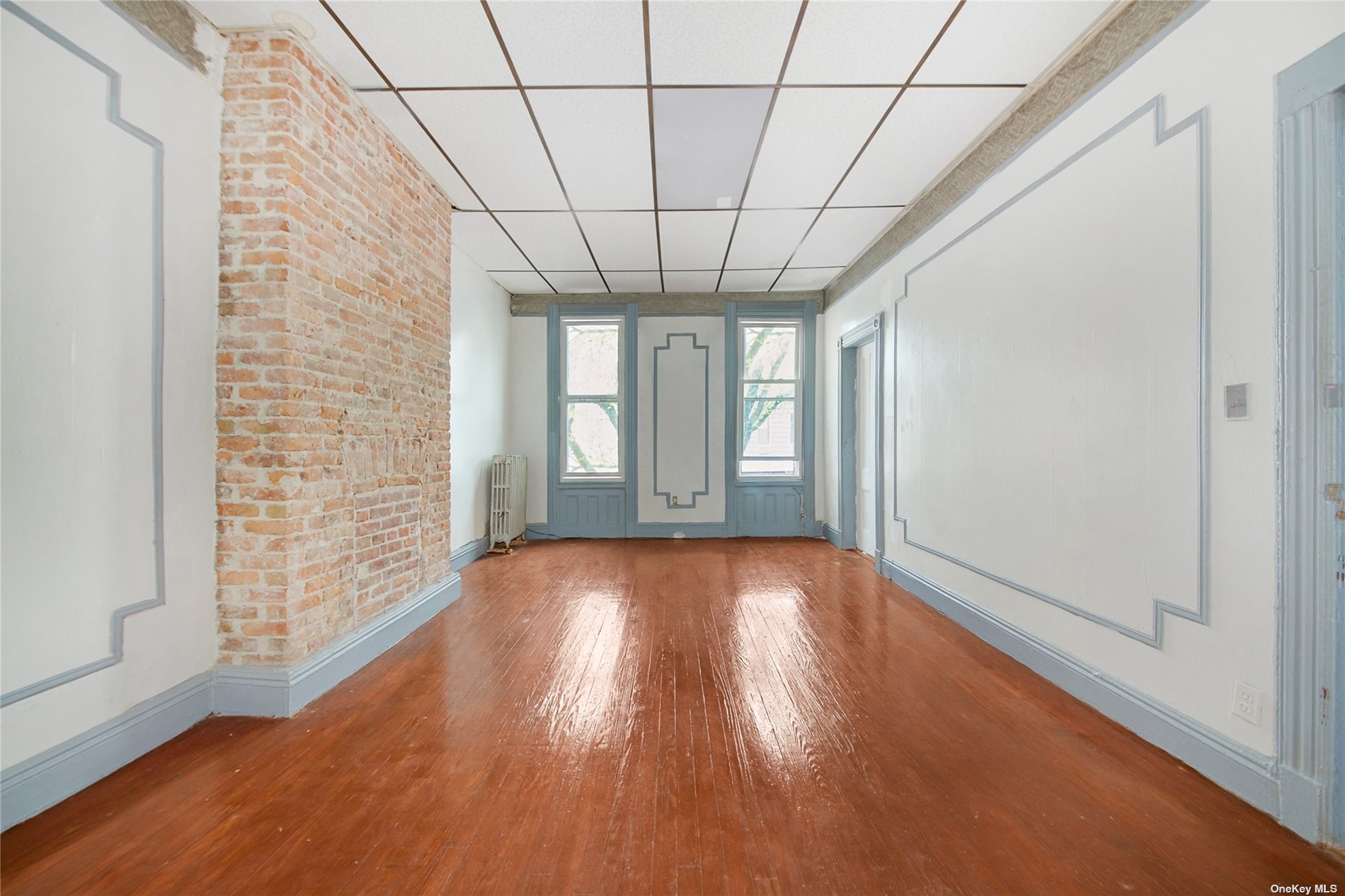 20 Weirfield Street Brooklyn, NY 11221 - Photo 7 of 12 a view of empty room with wooden floor and fan