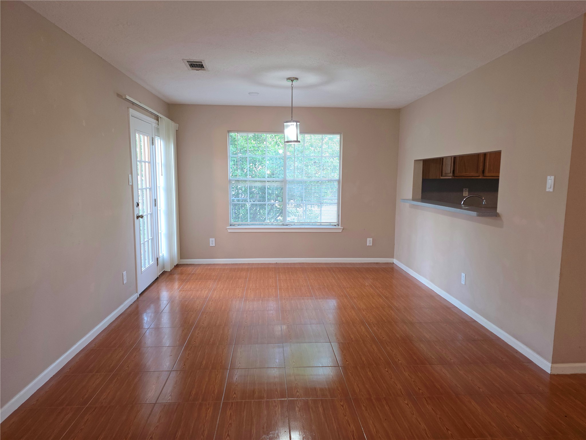414 Texas Street Tomball, TX 77375 - Photo 2 of 8 a view of an empty room with wooden floor and a window