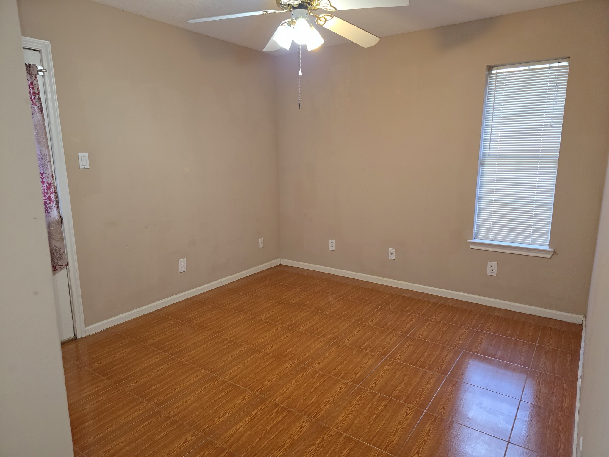 414 Texas Street Tomball, TX 77375 - Photo 5 of 8 an empty room with windows and fan