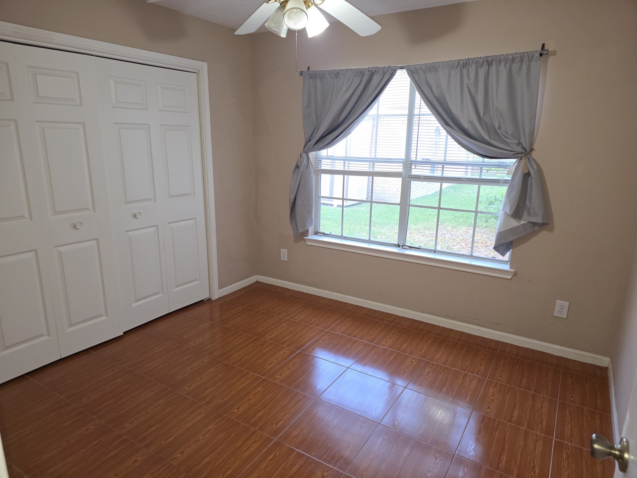 414 Texas Street Tomball, TX 77375 - Photo 6 of 8 an empty room with wooden floor chandelier and windows