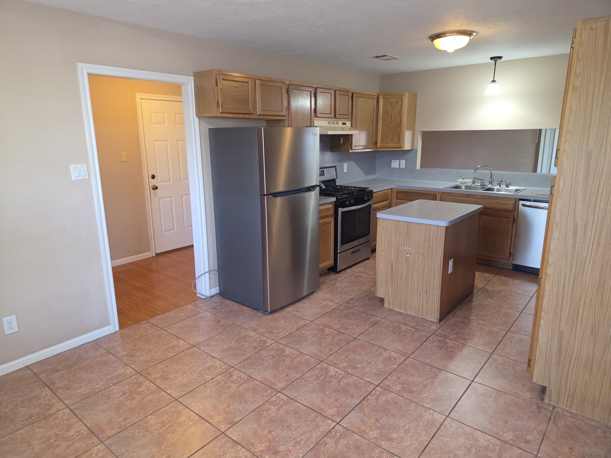 414 Texas Street Tomball, TX 77375 - Photo 7 of 8 a kitchen with granite countertop a refrigerator and a sink