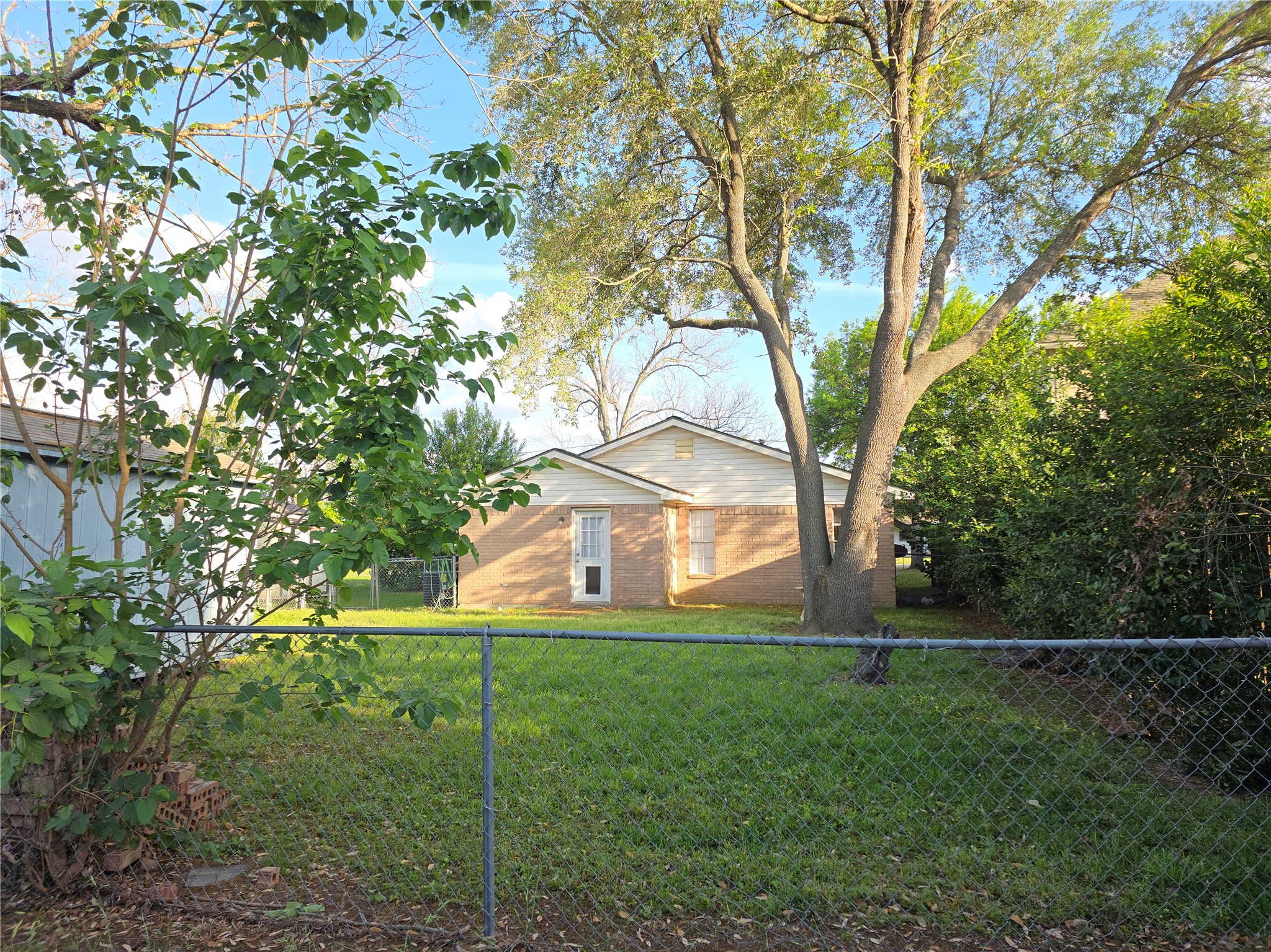 414 Texas Street Tomball, TX 77375 - Photo 8 of 8 a view of house in front of a big yard with large trees