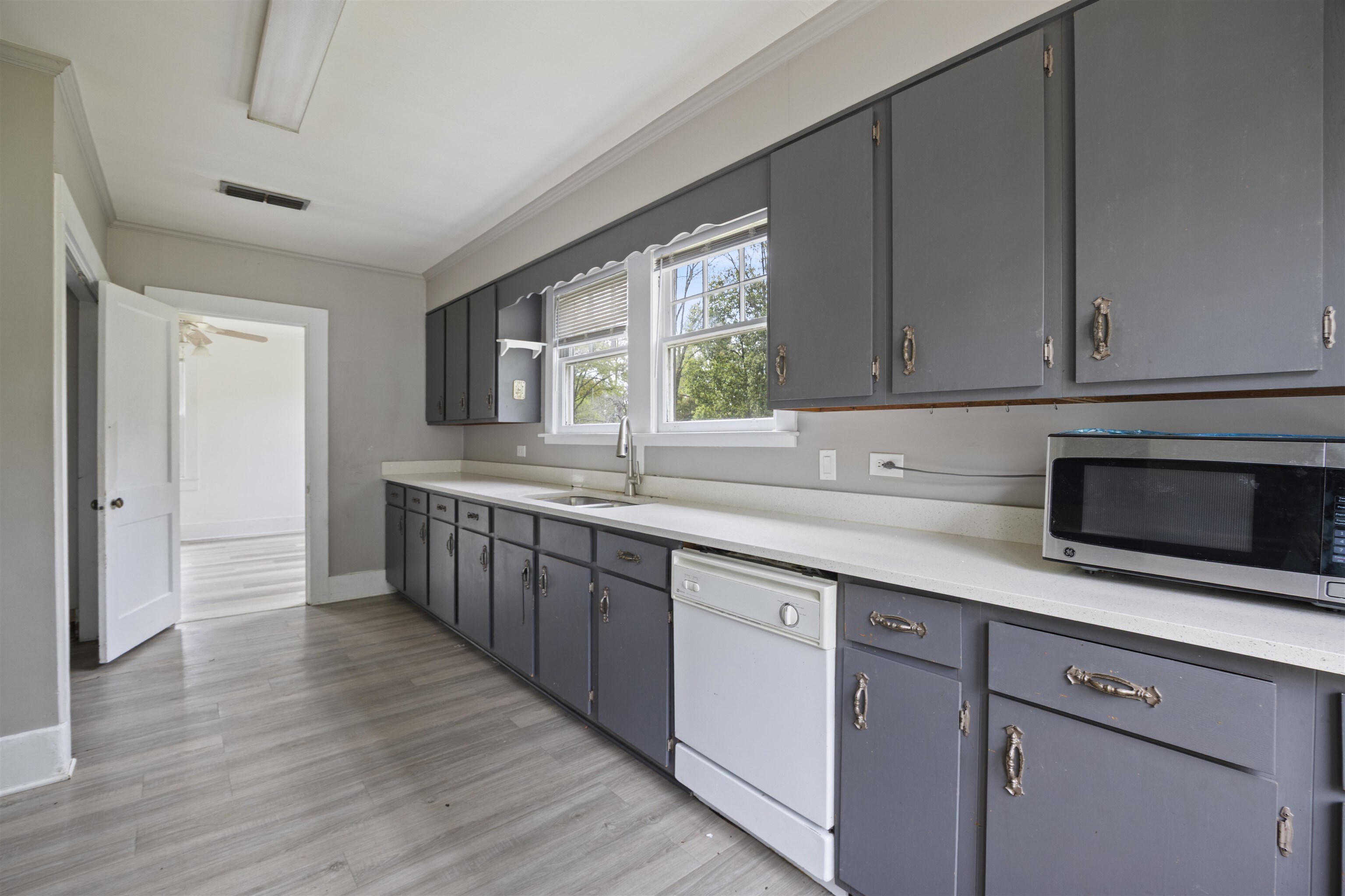 112 South Juniper Street Foley, AL 36535 - Photo 35 of 64 Kitchen with light countertops, white dishwasher, stainless steel microwave, gray cabinetry, and ornamental molding