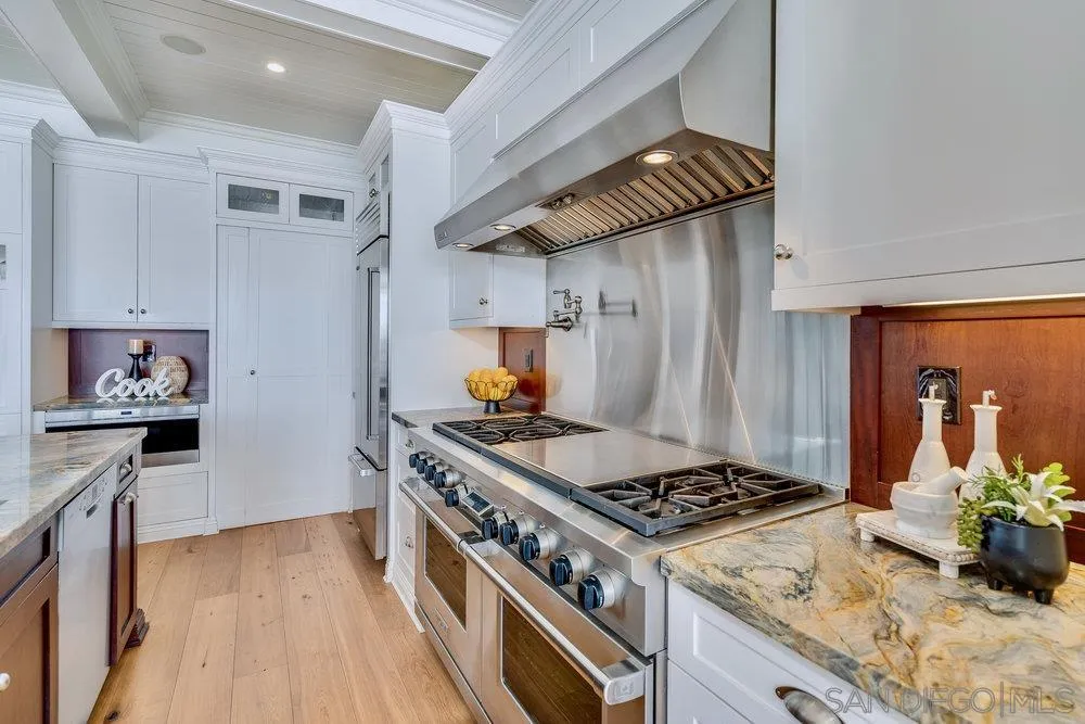 919 Ocean Boulevard Coronado, CA 92118 - Photo 12 of 63 a kitchen with stainless steel appliances granite countertop a stove and a wooden floors