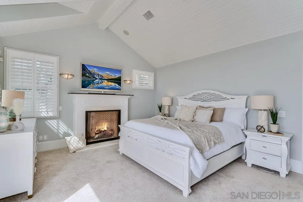 919 Ocean Boulevard Coronado, CA 92118 - Photo 25 of 63 a spacious bedroom with a bed and a fireplace