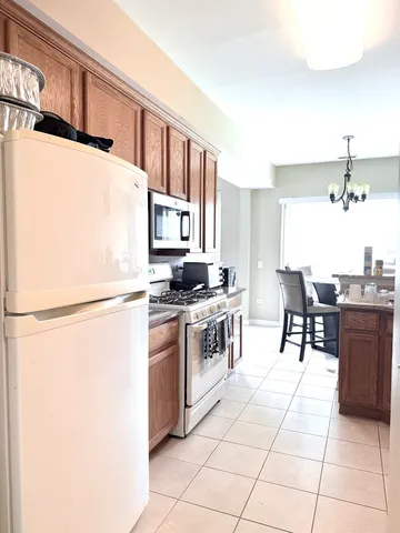 a kitchen with granite countertop a refrigerator and a stove top oven