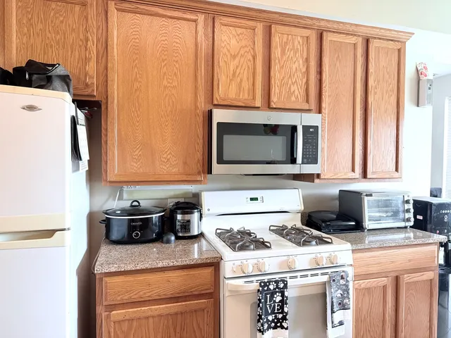 a kitchen with granite countertop a sink a stove and a microwave