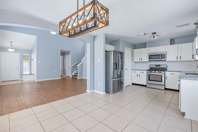 a kitchen with stainless steel appliances kitchen island granite countertop a refrigerator and a stove top oven