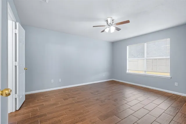 an empty room with windows and fan