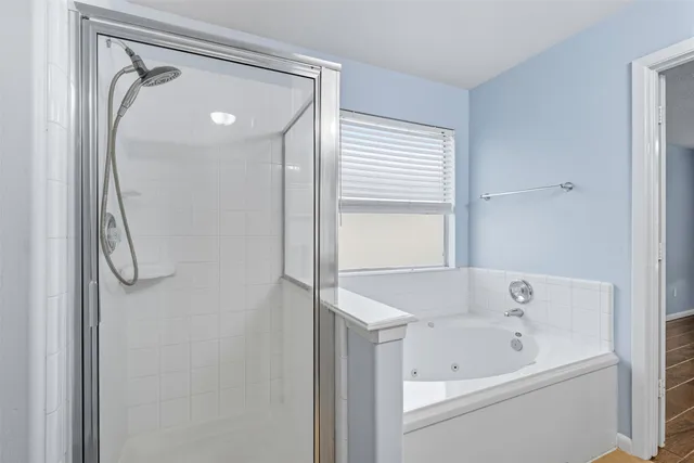 a bathroom with a tub a sink and a mirror