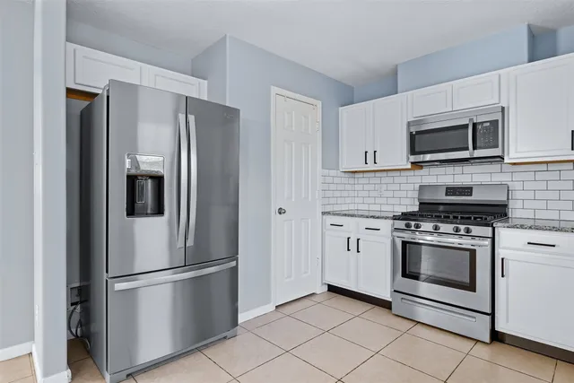 a kitchen with stainless steel appliances granite countertop a refrigerator stove and microwave