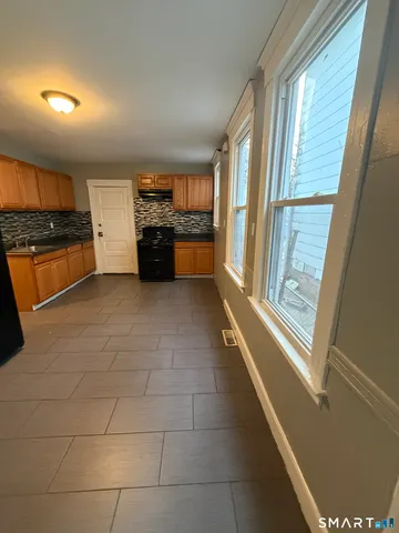 a view of a refrigerator in kitchen and a window