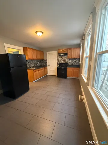 a open kitchen with stainless steel appliances a sink and a refrigerator