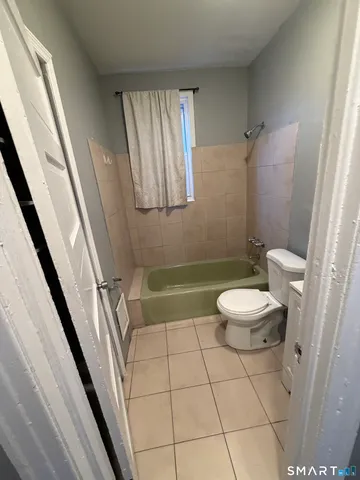 a bathroom with a sink a toilet a mirror and shower