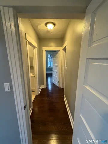 a view of a hallway with wooden floor and staircase