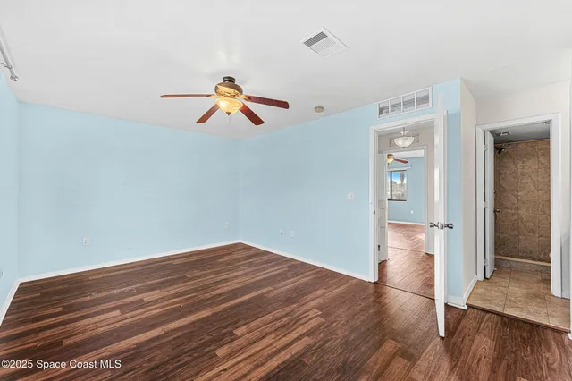 a view of empty room with wooden floor