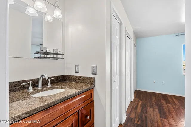 a bathroom with a granite countertop sink and a mirror