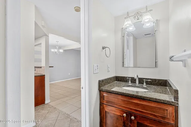a bathroom with a granite countertop sink a mirror and shower