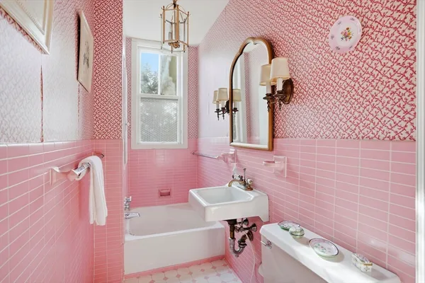 a bathroom with a tub sink and mirror