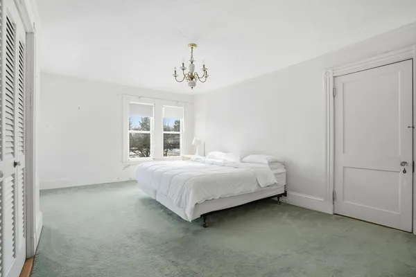 a spacious bedroom with a bed and a window