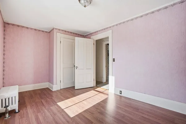 a view of an empty room with wooden floor