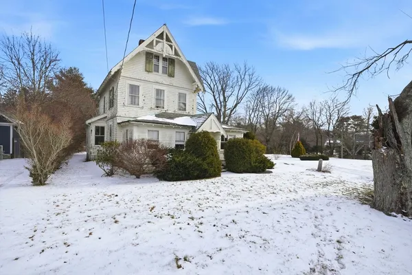 a front view of a house with a yard covered in snow