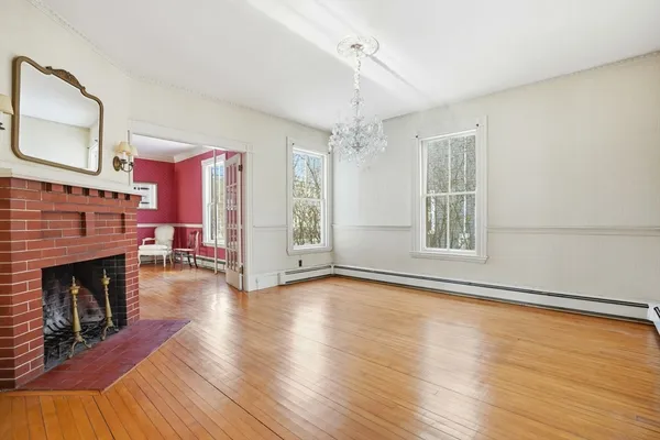a view of a livingroom with wooden floor and a fireplace