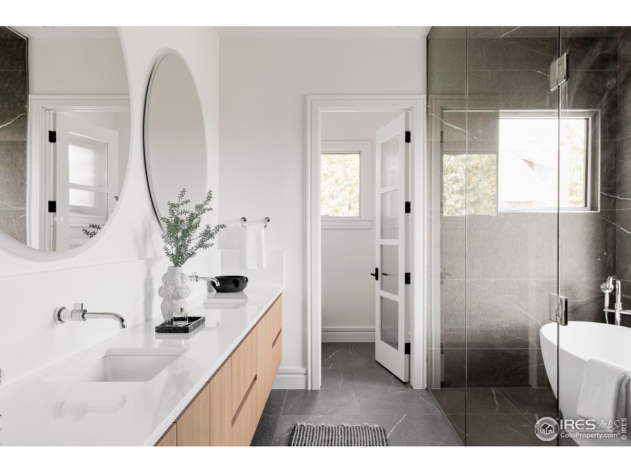6880 St Vrain Road Longmont, CO 80503 - Photo 18 of 37 a bathroom with a double vanity sink mirror and toilet