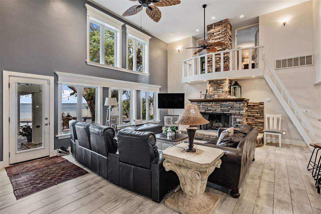 615 North Mayo Street Palm Harbor, FL 34683 - Photo 17 of 73 a living room with furniture a fireplace and a floor to ceiling window