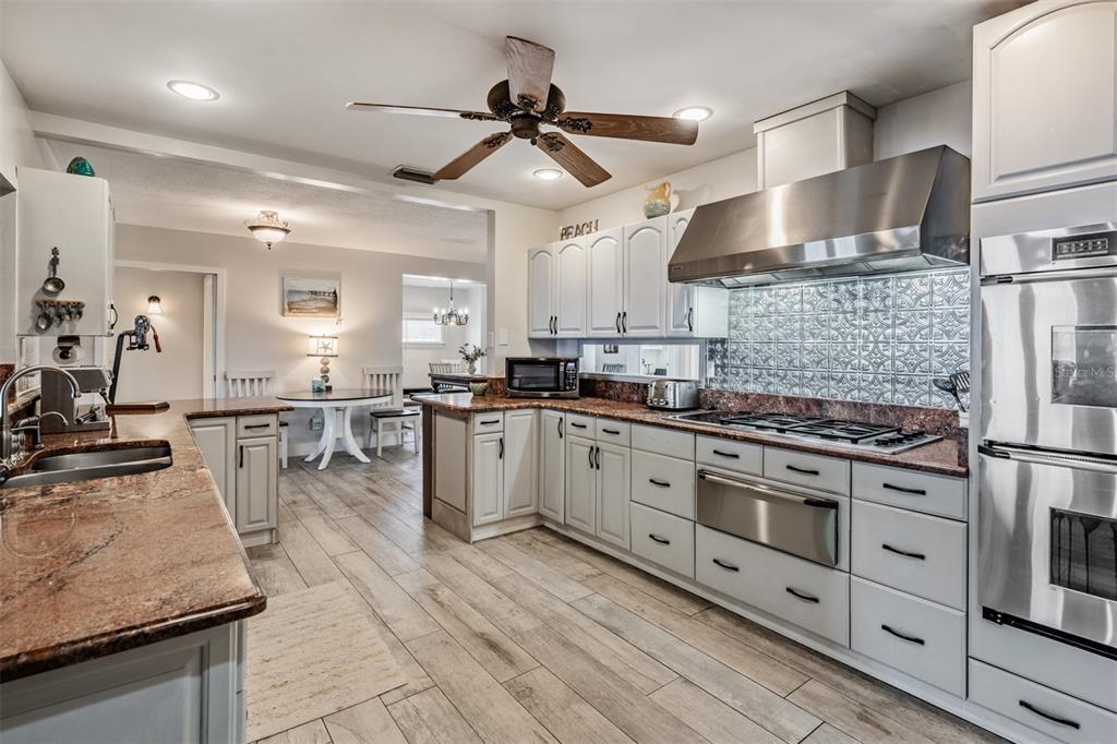 615 North Mayo Street Palm Harbor, FL 34683 - Photo 19 of 73 a kitchen with stainless steel appliances granite countertop a stove refrigerator and cabinets