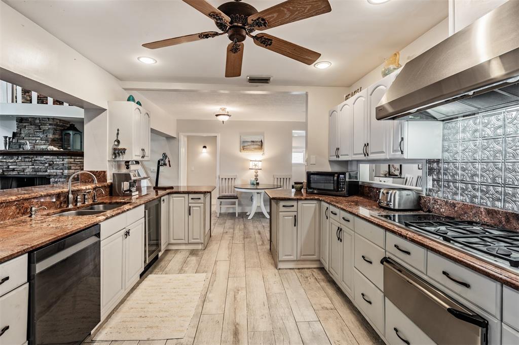 615 North Mayo Street Palm Harbor, FL 34683 - Photo 20 of 73 a kitchen with stainless steel appliances kitchen island granite countertop a stove top oven a sink a counter space and cabinets